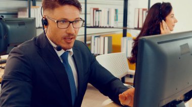 Ofiste çalışan kulaklık takan iş adamları.