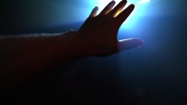 Parlayan ışığı kapatmak için uzanan el.