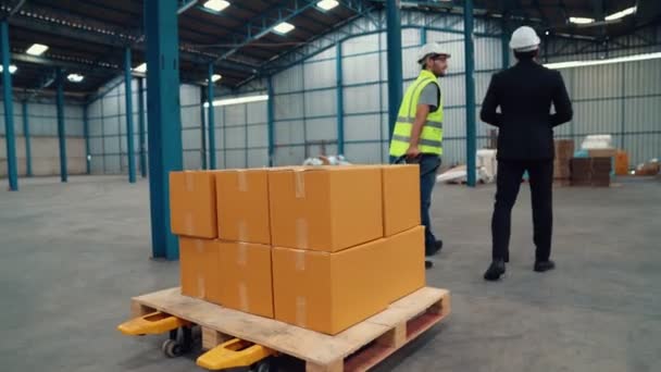 Trabalhadores da fábrica entregar caixas pacote em um carrinho de empurrar no armazém . — Vídeo de Stock
