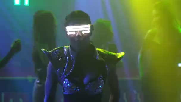 Grupp av människor dansar i disco nattklubb till rytmen av musik från DJ på scenen — Stockvideo