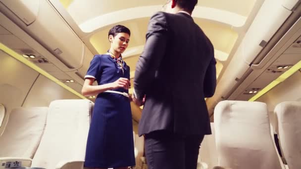 Экипаж салона приветствует пассажиров в самолете — стоковое видео
