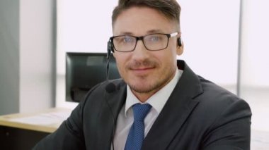 Ofiste çalışan kulaklık takan iş adamları.