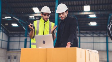 Fabrikada çalışan ve üretim planını tartışan iki fabrika işçisi. .