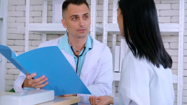 Doutor em uniforme profissional examinando paciente no hospital — Fotografia de Stock