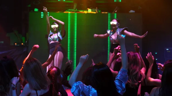 Gruppe tanzt in Disco-Nachtclub zum Beat der Musik von DJ auf der Bühne — Stockfoto