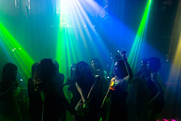 Disko gece kulübünde DJ 'in sahnede yaptığı müzikle dans eden insanların silueti. — Stok fotoğraf