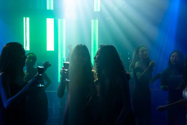 Disko gece kulübünde DJ 'in sahnede yaptığı müzikle dans eden insanların silueti. — Stok fotoğraf