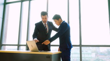 İki iş adamı ofiste proje stratejisi hakkında konuşuyor