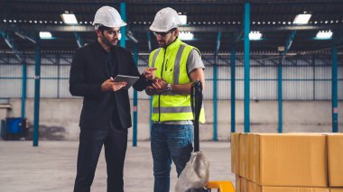 Fabrikada çalışan ve üretim planını tartışan iki fabrika işçisi. .