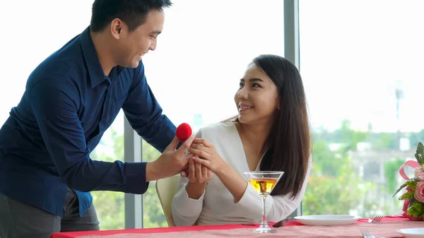 Romantic couple giving gift to lover at restaurant — Stock Photo, Image