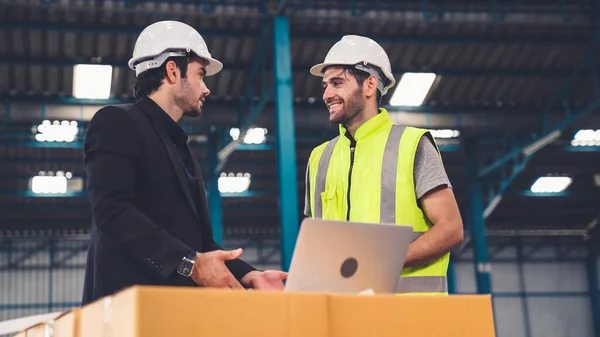 Två fabriksarbetare arbetar och diskuterar tillverkningsplan i fabriken . — Stockfoto