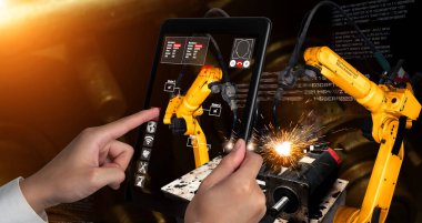 Mühendis, artırılmış gerçeklik endüstrisi teknolojisiyle robotik kolları kontrol ediyor.