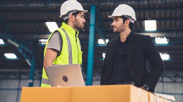 Två fabriksarbetare arbetar och diskuterar tillverkningsplan i fabriken . — Stockfoto