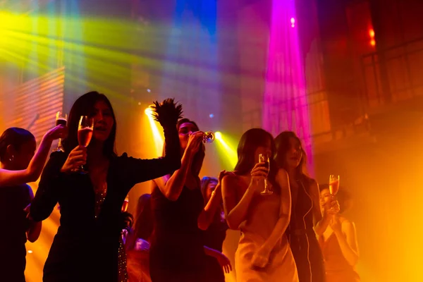 Silhouet beeld van mensen dansen in disco nachtclub op muziek van DJ op het podium — Stockfoto