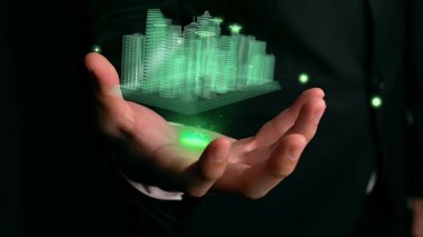 İşadamı gelişmiş gerçeklik teknolojisini gösteren 3D şehir modelini elinde tutuyor