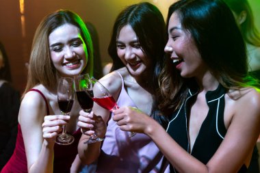 Gençler parti veriyor, içiyor ve dans ediyor.