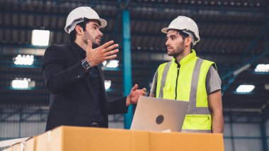 Fabrikada çalışan ve üretim planını tartışan iki fabrika işçisi. .