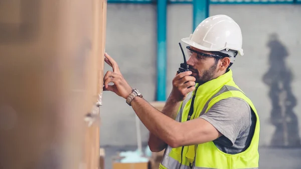 Trabajador de carga profesional habla por radio portátil para contactar a otro trabajador — Foto de Stock