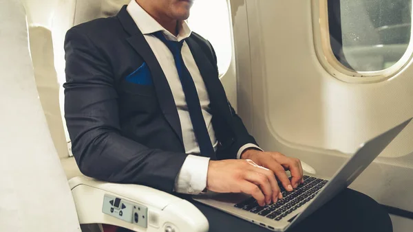 Joven hombre de negocios usando computadora portátil en avión — Foto de Stock