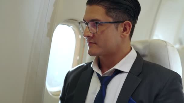 Joven hombre de negocios usando computadora portátil en avión — Vídeo de stock