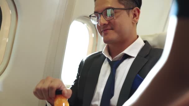 Affärsman har apelsinjuice serveras av en flygvärdinna i flygplan — Stockvideo