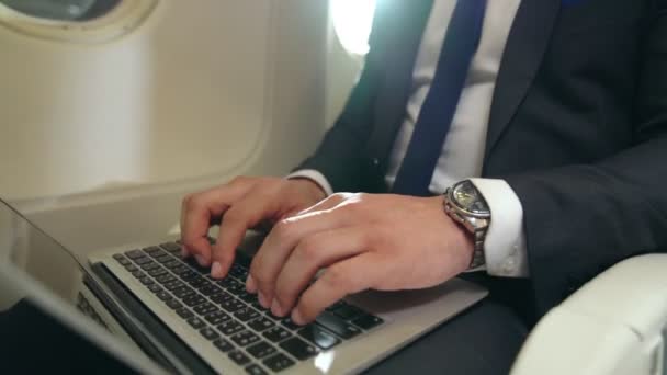 Mladý podnikatel pomocí notebooku v letadle — Stock video