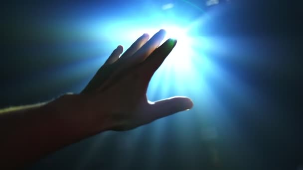 Hand reaching out to cover shinning spot light — Stock Video