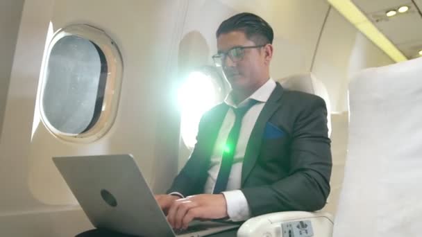 Joven hombre de negocios usando computadora portátil en avión — Vídeo de stock