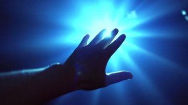 Parlayan ışığı kapatmak için uzanan el.