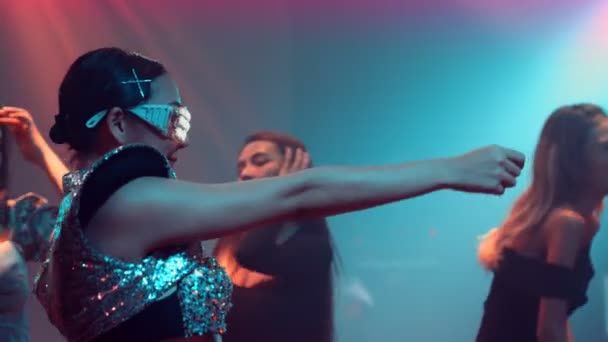 Группа людей танцует в дискотечном ночном клубе под ритм музыки от DJ на сцене — стоковое видео