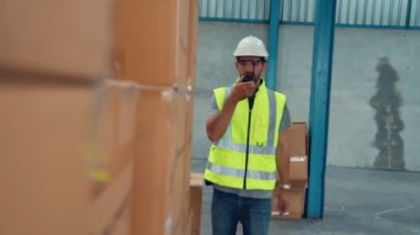 Profesyonel kargo işçisi başka bir işçiyle bağlantı kurmak için telsizle konuşuyor.