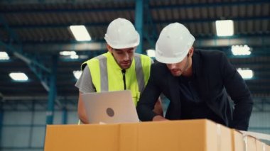 Fabrikada çalışan ve üretim planını tartışan iki fabrika işçisi. .