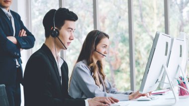 Ofiste çalışan kulaklık takan iş adamları.