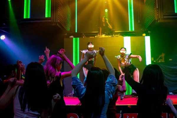 一群人在迪斯科夜总会随着DJ的音乐节拍在舞台上跳舞 — 图库照片