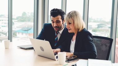 İki iş adamı ofiste proje stratejisi hakkında konuşuyor