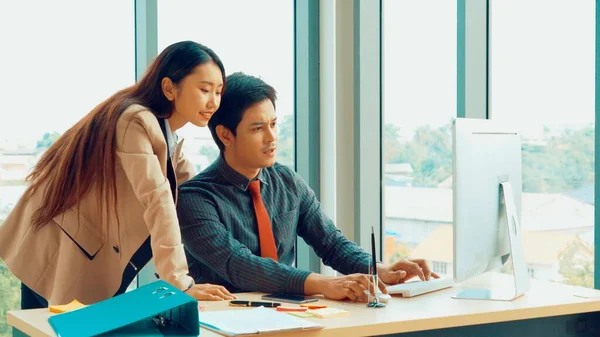 Two business people talk project strategy at office