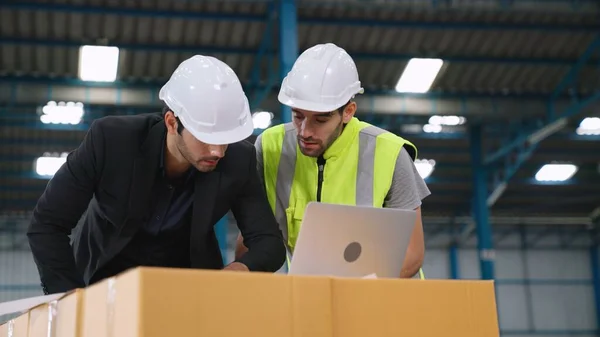 Fabrikada çalışan ve üretim planını tartışan iki fabrika işçisi. . — Stok fotoğraf