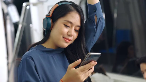 Jeune femme utilisant un téléphone portable dans le train public — Photo