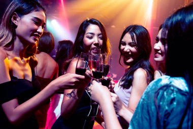 Gençler parti veriyor, içiyor ve dans ediyor.