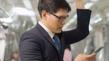 İş adamı trende cep telefonu kullanıyor.