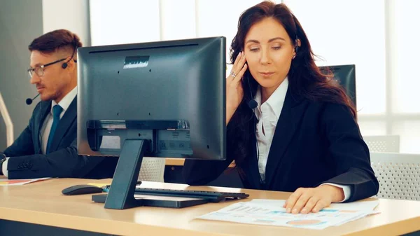 Empresários que usam auscultadores a trabalhar no escritório — Fotografia de Stock