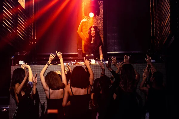 Ομάδα ανθρώπων χορεύουν στο νυχτερινό κλαμπ ντίσκο στο ρυθμό της μουσικής από DJ στη σκηνή — Φωτογραφία Αρχείου