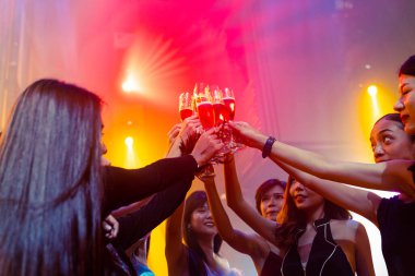 Gençler parti veriyor, içiyor ve dans ediyor.