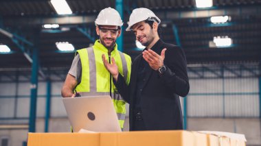 Fabrikada çalışan ve üretim planını tartışan iki fabrika işçisi. .