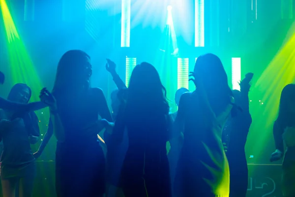 Силуетне зображення людей, які танцюють в нічному клубі диско до музики від DJ на сцені — стокове фото
