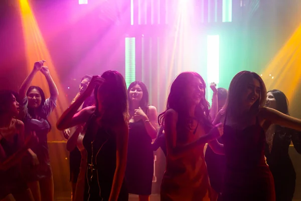 Silhouet beeld van mensen dansen in disco nachtclub op muziek van DJ op het podium — Stockfoto