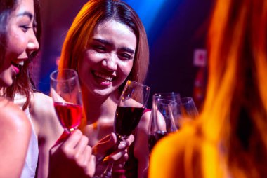 Gençler parti veriyor, içiyor ve dans ediyor.