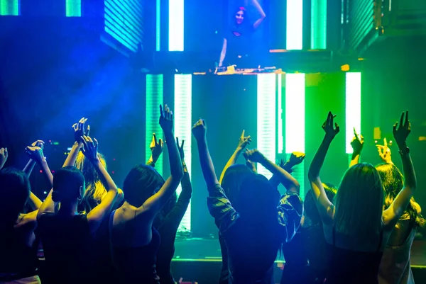 Silhouette kép az emberek táncolnak disco night club zenét DJ a színpadon — Stock Fotó