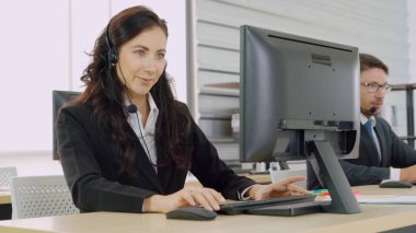 Ofiste çalışan kulaklık takan iş adamları.