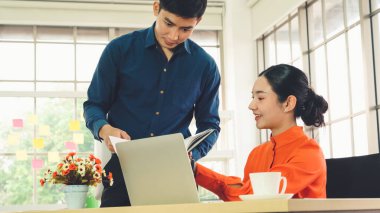 İki iş adamı ofiste proje stratejisi hakkında konuşuyor